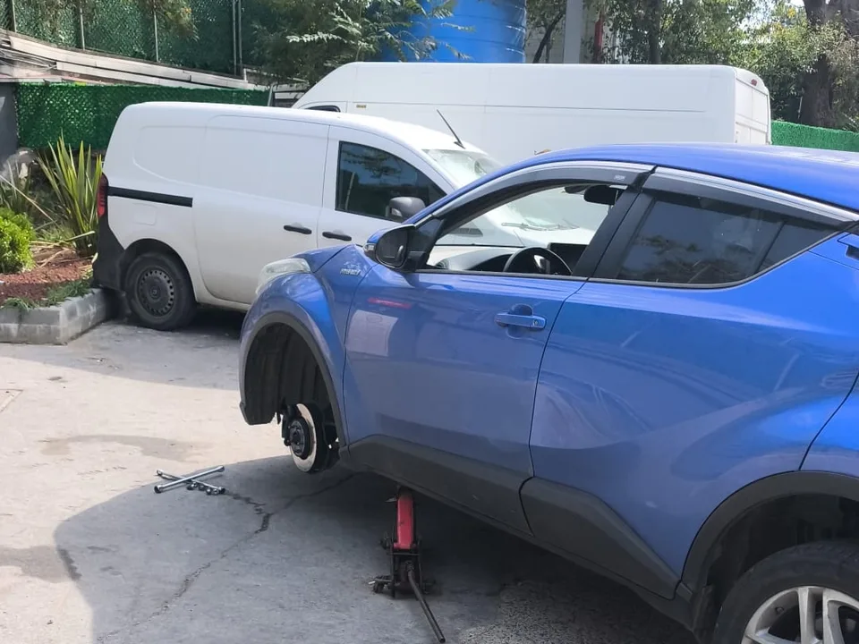 Otoparkta kriko ile kaldırılmış araçta tekerlek değişimi — Silivri için örnek çalışma fotoğrafı