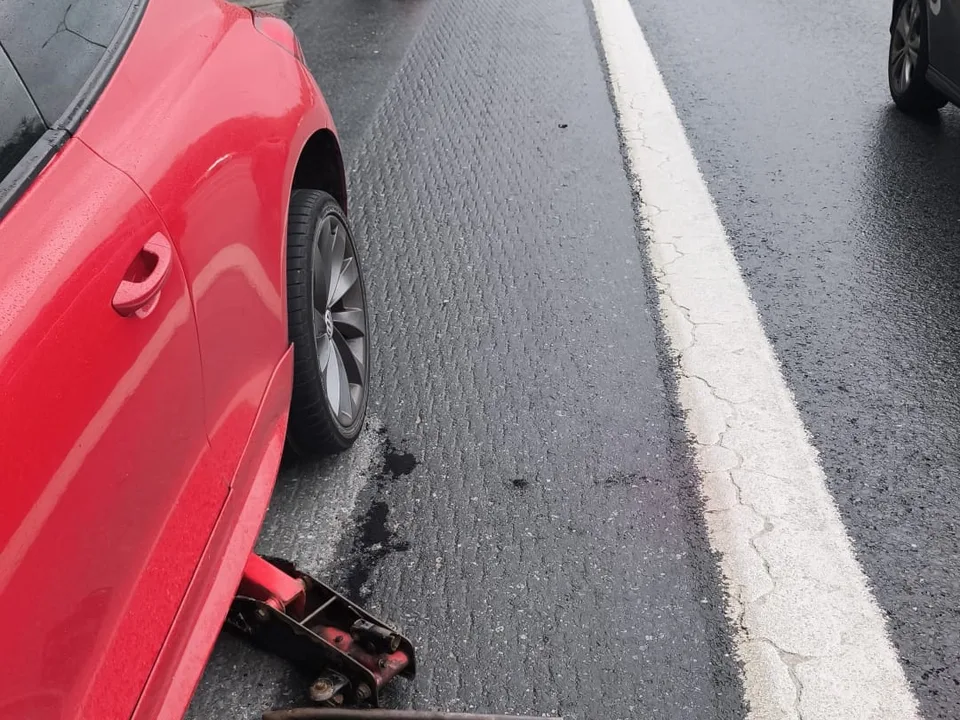 Yol kenarında emniyet konisiyle korunan alanda kriko ile lastik değişimi — Esenyurt için örnek çalışma fotoğrafı