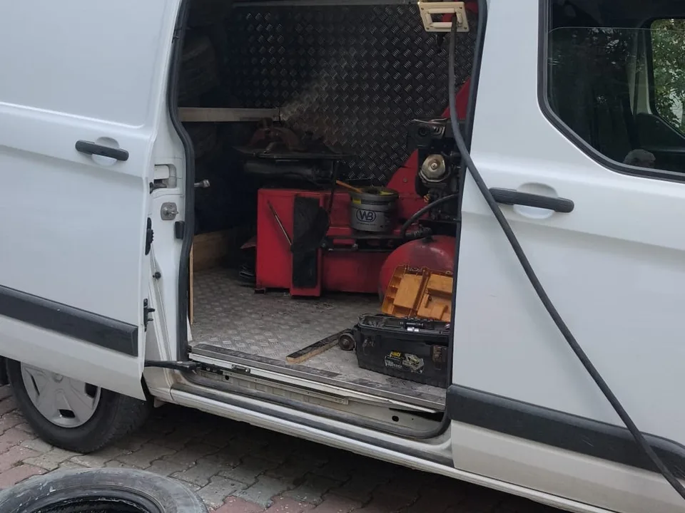 Ekipmanla donatılmış servis aracı ve yanında yığılı lastikler — Çatalca için örnek çalışma fotoğrafı