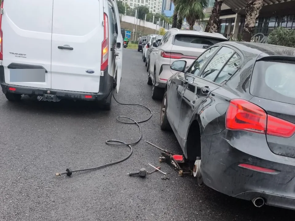 Cadde kenarında park halindeki araçta tekerlek sökülmüş, yerde havalı tabanca hortumu — Şile için örnek çalışma fotoğrafı
