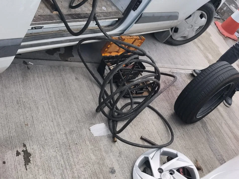 Servis aracından uzanan hava hortumu, sökülmüş tekerlek ve jant kapağı — Beyoğlu için örnek çalışma fotoğrafı