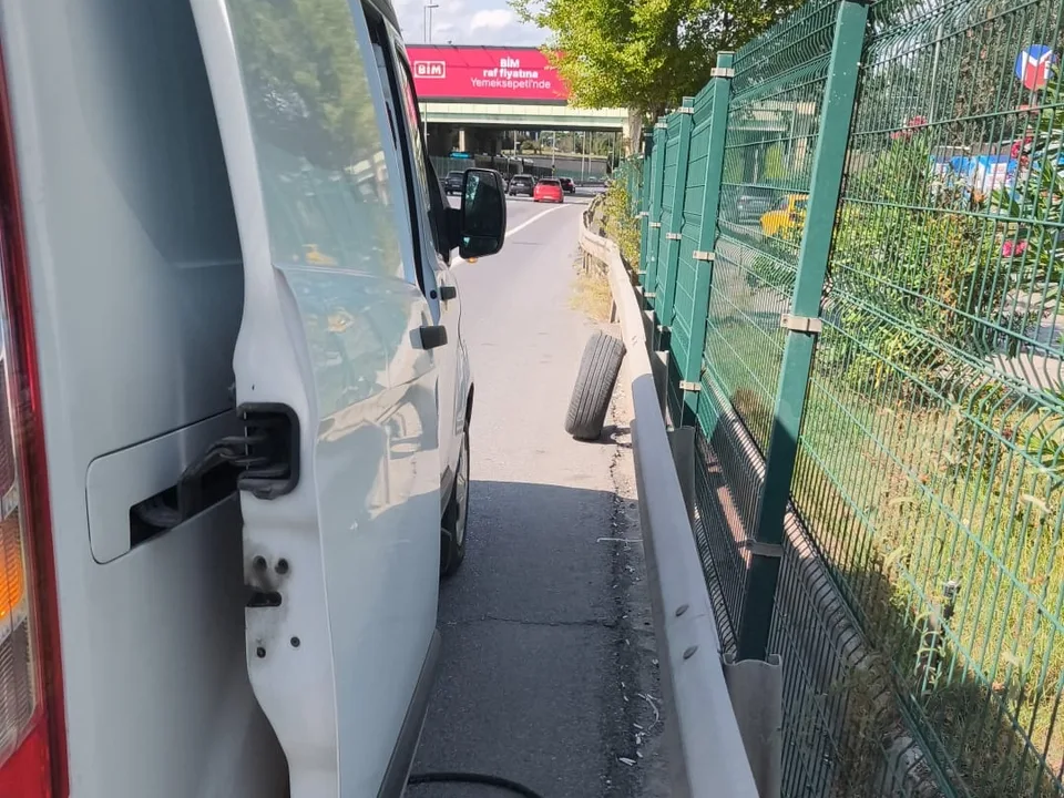 Yol kenarında bariyer ve çit önünde kapısı açık servis aracı — Bakırköy için örnek çalışma fotoğrafı