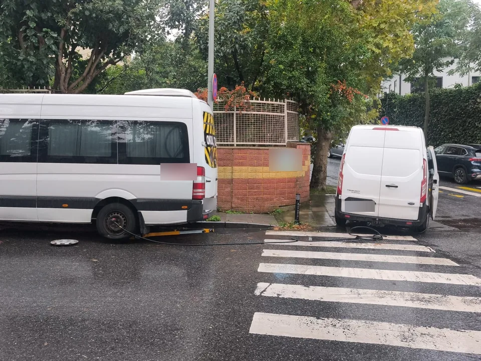 Yağışlı havada yaya geçidi yanında park halindeki minibüs ve servis aracı — Bayrampaşa için örnek çalışma fotoğrafı